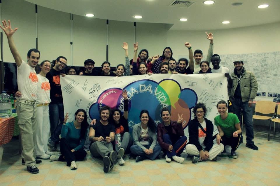 Apêiara students holding a signed Roda da Vida banner